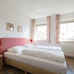 Bedroom in WEIDEVILLA B 6, Hollum, Ameland, vacation home with bright interior and comfortable beds.