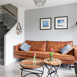 Komfortables Wohnzimmer des Amelander Kaap 126 in Hollum, Ameland, mit gemuetlichem Sofa und moderner Einrichtung.