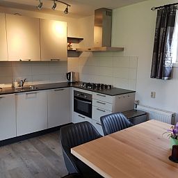 Moderne Kueche im Ferienhaus Piggelmee, Hollum, Ameland, mit Essecke und Geraeten.