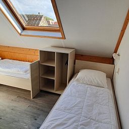 Gemuetliches Schlafzimmer mit Dachfenster im Ferienhaus Piggelmee, Hollum, Ameland.