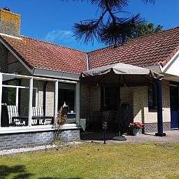 Luftaufnahme von "De Vrijheid", einem Ferienhaus in Hollum auf Ameland, umgeben von gruener Natur und nahegelegenen Duenen auf den Watteninseln.