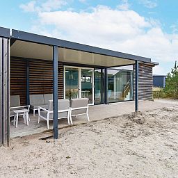 Terras van vakantiehuis Vrijstaande woning in Hollum op Ameland, omgeven door zand en groen.