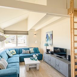Gezellige woonkamer in Eilandlodge 4, een vakantiehuis in Hollum, Ameland, met comfortabele zithoek en moderne inrichting.