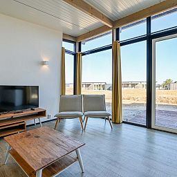 Helles Wohnzimmer eines freistehenden Hauses in Hollum, Ameland, Ferienhaus mit groen Fenstern auf den Watteninseln.