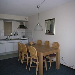 Gezellige eetruimte in Amelander Kaap nr. 54, een appartement in Hollum, Ameland, Waddeneilanden, met moderne keukenfaciliteiten.