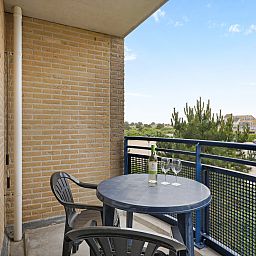 Balkon van Ameland State 2-persoons appartement in Nes, Ameland, met uitzicht op de groene omgeving.