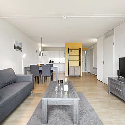 Open woonruimte in Ameland State appartement in Nes, Ameland, met moderne keuken en eethoek.