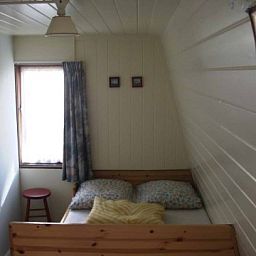Gemtliches Schlafzimmer im Ferienhaus Huisje Schier auf Schiermonnikoog, ideal fr eine erholsame Nachtruhe auf den Watteninseln.