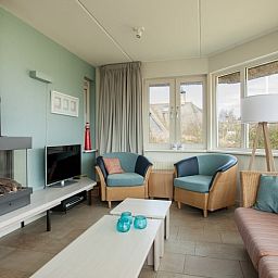 Gezellige woonkamer in Villa Rietberg, vakantiehuis op Schiermonnikoog met open haard.