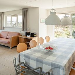 Eetkamer in Villa Rietberg, vakantiehuis Schiermonnikoog met ruime tafel en tuinzicht.