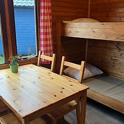 Cozy interior of Holiday Home in Workum with wooden interior, bunk bed and garden view in the Frisian lake region.