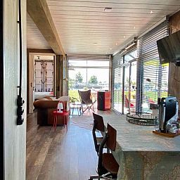 Moderne Kueche im Ferienhaus FR058, Warns, mit rotem SMEG-Kuehlschrank.