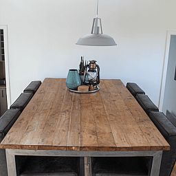 Spacious dining room in Holiday Home in Oudega, located on Lake Heeg in the Frisian Lakes, with a robust wooden table and modern furnishings.
