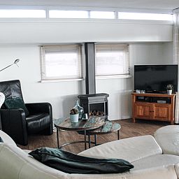 Cozy living room in Holiday Home in Oudega, located on Lake Heeg in the Frisian Lakes, with comfortable seating area and modern furnishings.