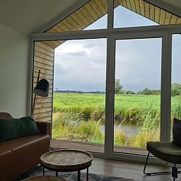 Uitzicht vanuit de woonkamer van Huisje in Oudega, vakantiehuis met panoramisch zicht op Friese meren.