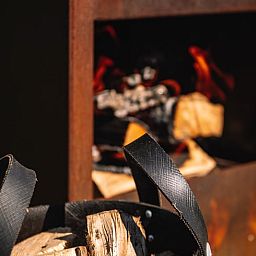 Aussenkamin mit brennendem Holz im Ferienhaus in Koudum, ideal fuer gemuetliche Abende.