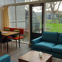 Gemuetliches Wohnzimmer des Ferienhauses in Gaastmeer, mit Blick auf den gruenen Garten in den Friesischen Seen, ideal zum Entspannen.