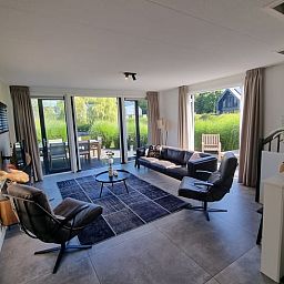 Geraeumige Sitzecke im Ferienhaus in Balk mit bequemen Stuehlen und viel natuerlichem Licht, in der Naehe von Slotermeer.