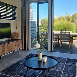 Gemuetlicher Innenbereich des Ferienhauses in Balk mit Zugang zur Terrasse und Blick auf die Natur.