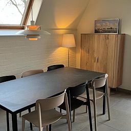 Cozy dining area in Bungalow Sneekermeer, Goingarijp. Vacation home with modern furnishings and garden views near Frisian lakes.