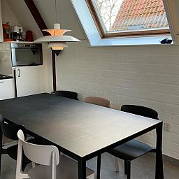 Kitchen and dining area in Bungalow Sneekermeer, Goingarijp, with modern decor and lots of light, ideal for a vacation on the Frisian lakes.