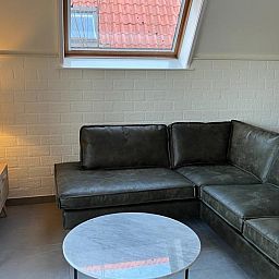 Cozy living room in Bungalow Sneekermeer, Goingarijp. Comfortable sitting area with natural light and modern decor near Frisian lakes.