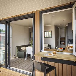 Kinder spielen mit einem Strandball vor dem Mobilheim de Klipper in Offingawier, Sneekermeer. Geniessen Sie das Mobilheim an den friesischen Seen.
