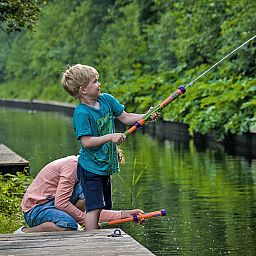Kinderen vissen in de natuurlijke omgeving van Vakantiehuis Bungalowpark It Wiid, Earnewald, nabij de Friese meren.