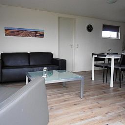 Moderne woonkamer in Vakantiewoningen Oostmahorn, Oostmahorn, met stijlvolle inrichting en veel lichtinval.