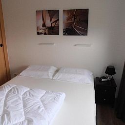 Slaapkamer met comfortabel tweepersoonsbed in Vakantiewoningen Oostmahorn, ideaal voor een goede nachtrust in Friese meren.