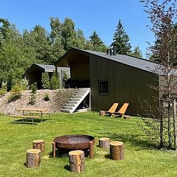 Zomerzicht op Vakantiehuisje in Spier, met groene tuin en buitenzitjes in Midden Drenthe.