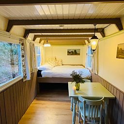 Cozy indoor area of Huisje in Papenvoort, a vacation home in Central Drenthe, with cozy dining area and views of nature.