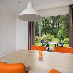 Gezellige eetruimte in Dotterbloem Chalet 4, Hooghalen, met uitzicht op groene natuur in Midden Drenthe, ideaal vakantiehuis voor rustzoekers.