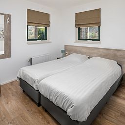 Gemuetliches Schlafzimmer im Stuifzand Wellness Bungalow 8, Hooghalen, Midden Drenthe mit bequemen Betten und natuerlichem Licht.