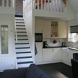 Open keuken met trap naar bovenverdieping in Huisje in Eesergroen, vakantiehuis in Midden Drenthe.