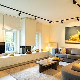 Comfortable bedroom in Hof van Saksen 8-bed farmhouse 8L, Nooitgedacht, Drenthe, with king-size bed and TV.