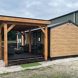 Spacious porch of the Cottage in Eeserveen, Drenthe surrounded by greenery.