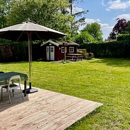 Grosszuegige Rasenflaeche mit Terrasse und Pavillon am Ferienhaus in Nieuw Balinge, ideal fuer Aktivitaeten im Freien.