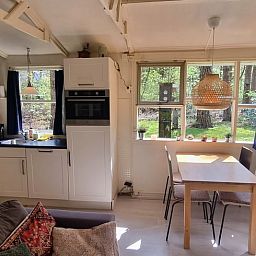 Gemuetlicher Innenbereich des Huisje in Norg, Ferienhaus in Nord-Drenthe, mit Kueche und Essbereich mit Blick auf die gruene Natur.