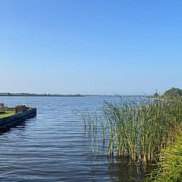 Atemberaubende Aussicht auf den See vom Cottage in Matsloot, einem Ferienhaus in Nord-Drenthe, umgeben von einer ruhigen Landschaft.