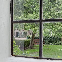 Uitzicht vanuit Vakantiehuisje in Dalerveen, Zuidoost Drenthe, met groene tuin en rustieke charme.