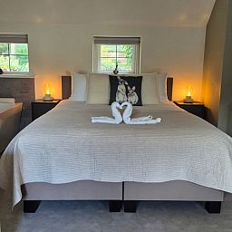 Gemuetliches Schlafzimmer im Cottage in Dalerveen, Suedost-Drenthe, mit einem bequemen Doppelbett und stimmungsvoller Beleuchtung.