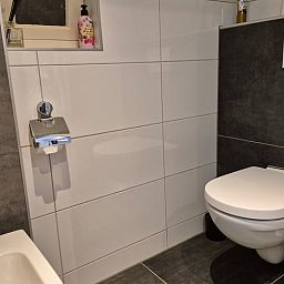 Modernes Badezimmer im Ferienhaus in Dalerveen, einem Ferienhaus im Suedosten von Drenthe. Stilvolle Sanitaerkeramik und moderne Fliesen fuer optimalen Komfort.
