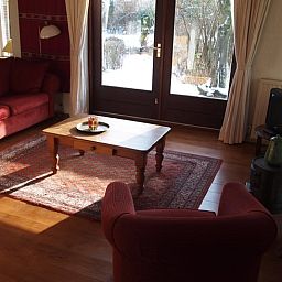 Comfortabele woonkamer met rood interieur in Vakantiehuis in Odoornerveen, Zuidoost Drenthe, Drenthe.