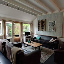 Gezellige woonkamer van Huisje in Zuidwolde, vakantiehuis in Zuidwest Drenthe, met comfortabele zitplekken en veel natuurlijk licht.