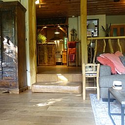 Gezellige woonkamer in Huisje in Zuidwolde, vakantiehuis in Zuidwest Drenthe, met rustieke houten meubels en warme inrichting.