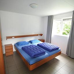Geraeumiges Schlafzimmer im Ferienhaus in Ruinen, Suedwest-Drenthe, mit bequemem Doppelbett und Blick auf die gruene Umgebung.