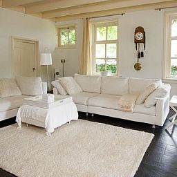 Gemuetliches Wohnzimmer in Hoeve den Anholt, Ruinen, Drenthe, mit bequemen Sofas und rustikalen Moebeln.