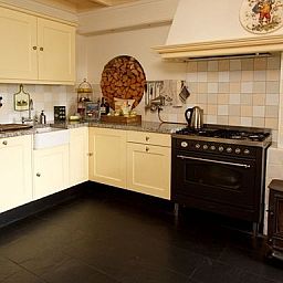 Laendliche Kuechenecke in Hoeve den Anholt, Ruinen, Drenthe, mit klassischem Ofen und stimmungsvollem Holzherd.