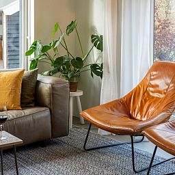 Eetruimte in Vakantiehuisje in Dwingeloo, Zuidwest Drenthe, met stijlvolle stoelen en zonnig uitzicht.